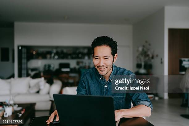 man working at home - usare il laptop foto e immagini stock