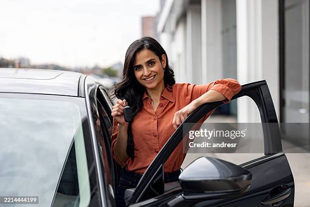 portrait of a woman holding the keys of her new car - buying a car stock pictures, royalty-free photos & images