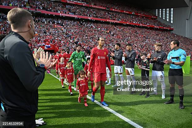 Virgil van Dijk of Liverpool leads the team out, as players of Arsenal and the match officials form a guard of honour prior to the Premier League...