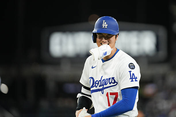 Shohei Ohtani of the Los Angeles Dodgers jokes on first base during the game between the Athletics and the Los Angeles Dodgers at Dodger Stadium on...