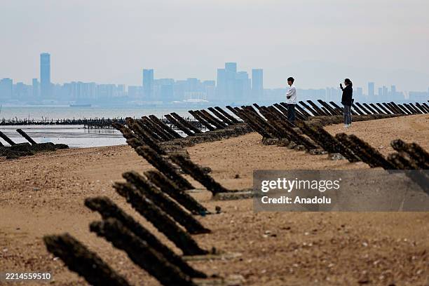 Tourist take pictures near the anti-landing spikes at a beach where the Chinese city of Xiamen is visible from afar, in Kinmen, Taiwan, on May 11,...