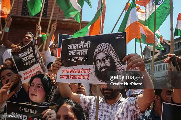 Supporters of India's Bharatiya Janata Party hold placards featuring portraits of Pakistan-based terrorist and Jaish-e-Mohammed chief Masood Azhar...