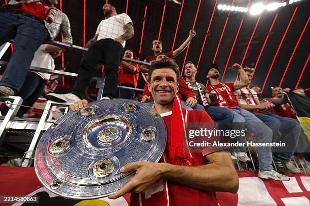 Thomas Mueller of Bayern Munich poses for a photograph as he celebrates with the Meisterschale trophy after the Bundesliga match between FC Bayern...