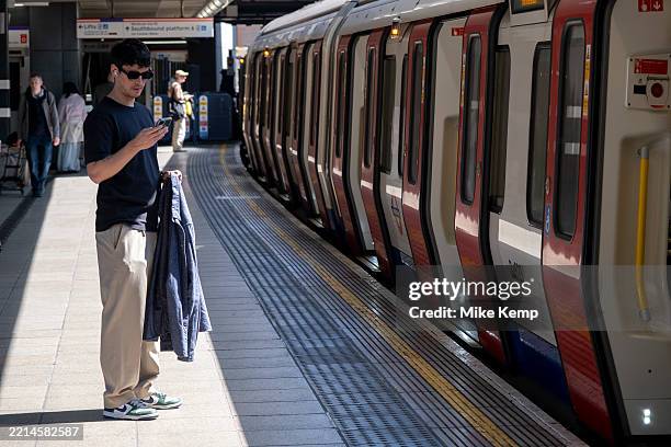 Person looking at their phone on the platform at London Underground Whitechapel station on 9th May 2025 in London, United Kingdom. The London...