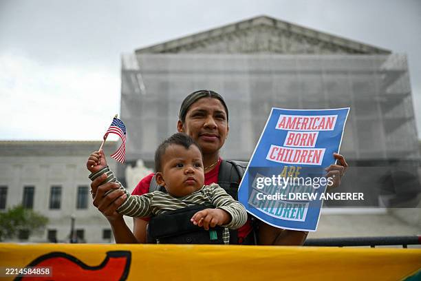 Olga Urbina and her 9 months son Ares Webster participate in a protest outside the US Supreme Court over President Donald Trump's move to end...