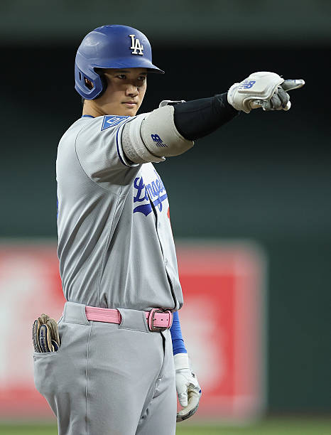 Shohei Ohtani of the Los Angeles Dodgers reacts after hitting a single against the Arizona Diamondbacks during the fifth inning of the MLB game at...