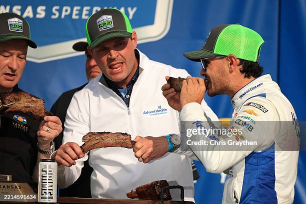 Kyle Larson, driver of the HendrickCars.com Chevrolet, eat ribs in victory lane after winning the NASCAR Cup Series AdventHealth 400 at Kansas...