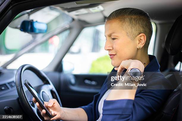 businesswoman using phone in a parked car - taxi driver stock pictures, royalty-free photos & images