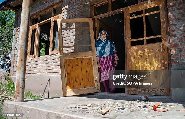 An Indian village woman looks on as she stands at the door of her house damaged in cross-border shelling in Uri, a town near the Line of Control ....