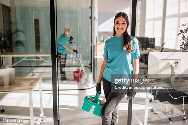 donna delle pulizie dell'ufficio in piedi pronta - impresa di pulizie foto e immagini stock