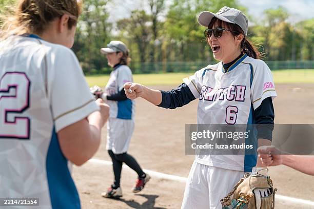 weibliches softball-team beim training auf einem feld in einem vorort von tokio - fairness stock-fotos und bilder