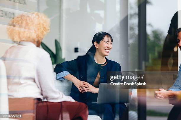 business team engaged in a productive meeting discussion - japanese ethnicity working woman stock pictures, royalty-free photos & images