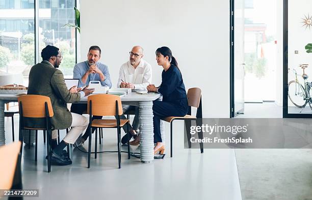 diverse team collaborating in modern office during business meeting - business meeting stockfoto's en -beelden