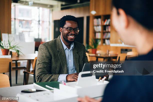 professional meeting in bright contemporary workspace with smiling businessman - creative space stock pictures, royalty-free photos & images