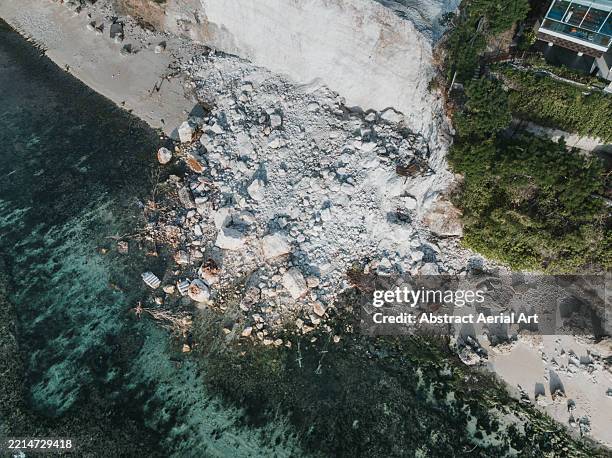 drone image looking down on a landslide covering a beach alongside the indian ocean, badung regency, bali, indonesia - landslide stock pictures, royalty-free photos & images