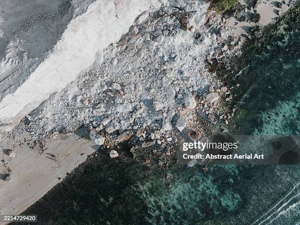 overhead photograph showing a landslide covering a beach caused during the excavation of coastal limestone cliffs, uluwatu, bali, indonesia - eroded stock pictures, royalty-free photos & images