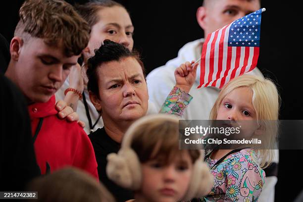 Newly arrived South Africans listen to representatives from Homeland Security and the State Department deliver welcome statements in a hangar at...