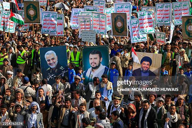 Protesters lift portraits of Yemeni Huthi leader Abdul-Malik al-Huthi , slain Iranian commander Qasem Soleimani , and Lebanese Hezbollah's slain...
