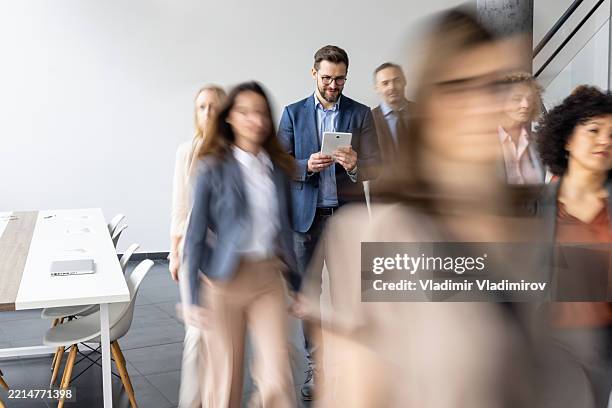 fokussierte personen, die im büro mit digitalen geräten umgehen - bewegungsunschärfe stock-fotos und bilder