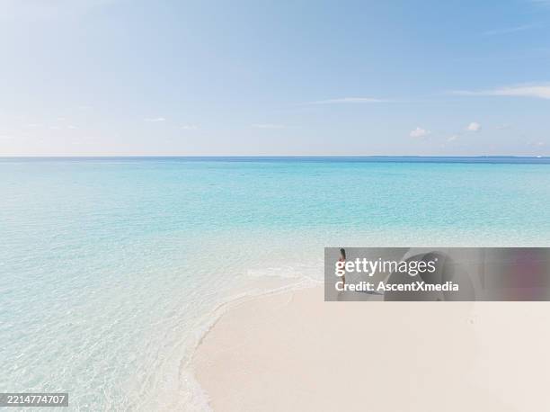 luftaufnahme der jungen frau zu fuß auf tropischen strand - malediven stock-fotos und bilder