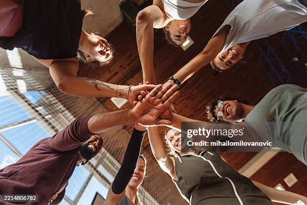 bottom view of basketball team stacking hands - handen ineengevouwen stockfoto's en -beelden