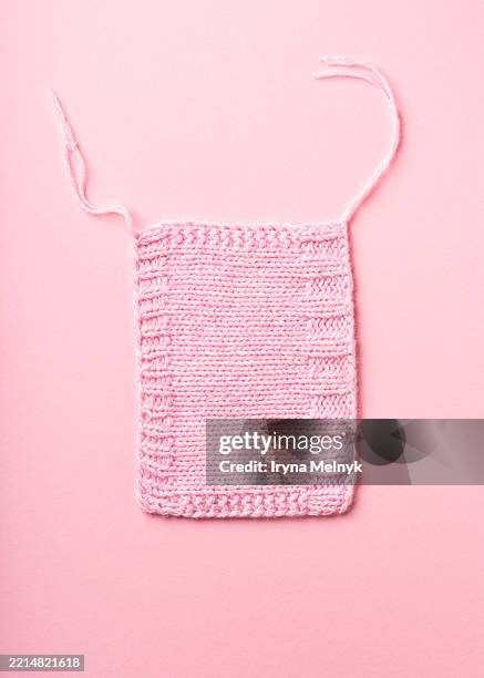 knitted pink swatch displayed on a soft pink background, showcasing intricate patterns and textures, perfect for textile design inspiration and crafting projects - knitting needles and wool stock pictures, royalty-free photos & images