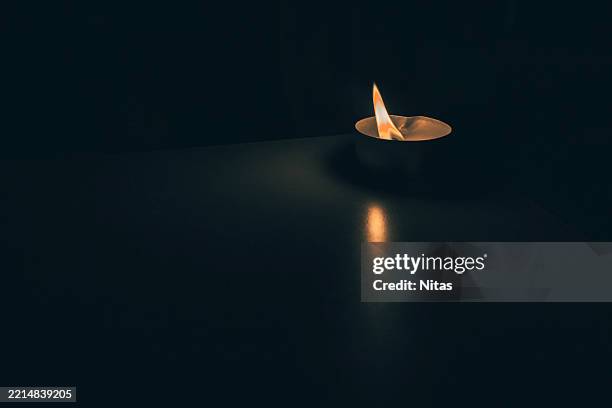small flickering candle flame illuminating dark room - apagão imagens e fotografias de stock