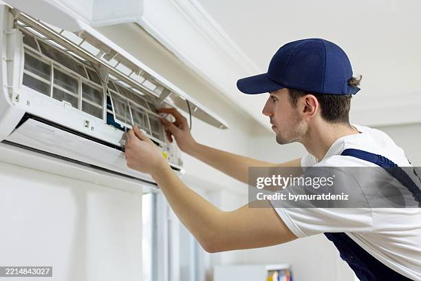 air conditioner technician repairing aircon - air conditioner stock pictures, royalty-free photos & images