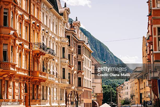 elegant urban street with colorful buildings and mountain backdrop - bolzano stock pictures, royalty-free photos & images