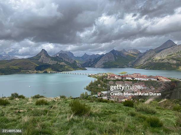 landscape view of a mountainous region with lakes and a picturesque village in the foreground under dramatic clouds - castille et leon photos et images de collection