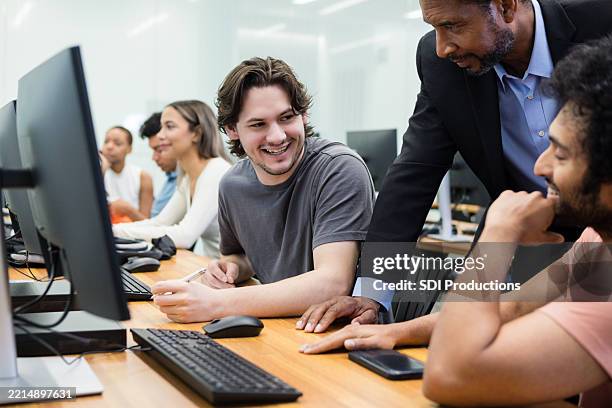 professor assisting students with computer lab homework - college students computer lab stock pictures, royalty-free photos & images
