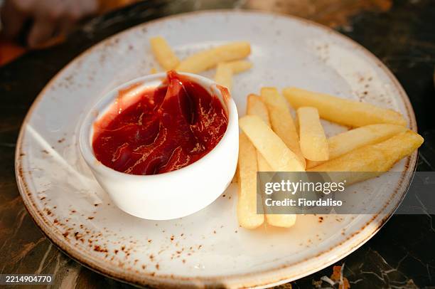 delicious plate of french fries with ketchup served on a rustic table - tomato ketchup stock pictures, royalty-free photos & images