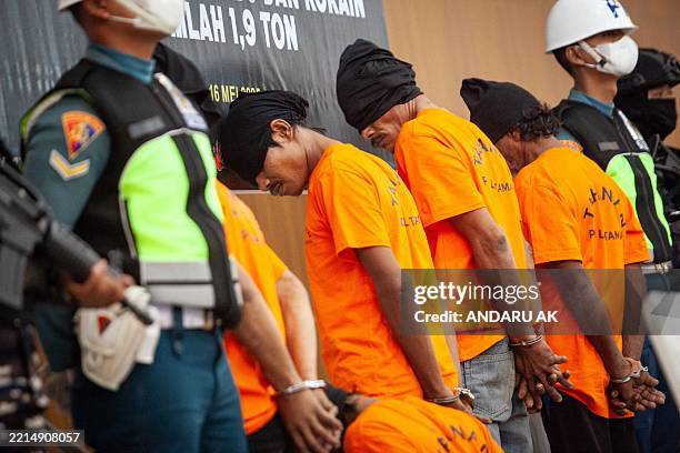 One Thai and four Myanmar suspects stand during a press conference with 705 kg of methamphetamine and 1.2 tonnes of cocaine seized from a Thai...