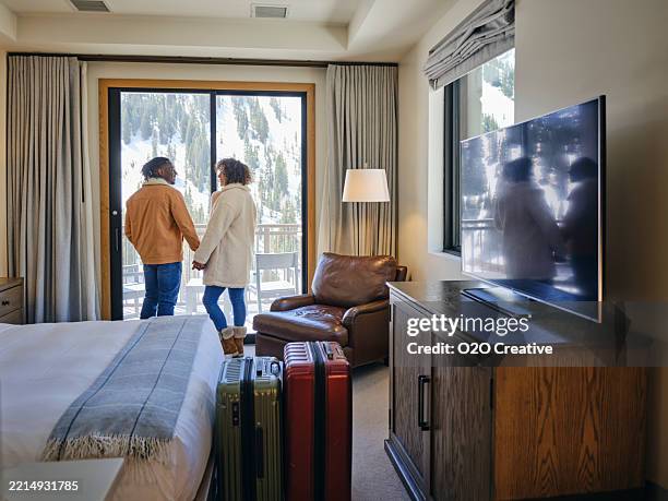 young couple in a hotel room at a ski resort - ski lodge stock pictures, royalty-free photos & images