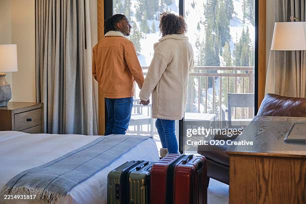 young couple in a hotel room at a ski resort - ski lodge stock pictures, royalty-free photos & images