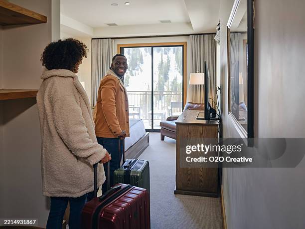 young couple in a hotel room at a ski resort - ski lodge stock pictures, royalty-free photos & images