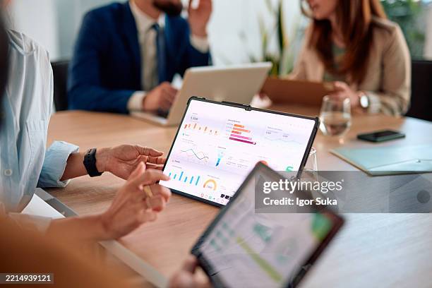 das business-team analysiert finanzdaten auf digitalen tablets während eines meetings - daten stock-fotos und bilder