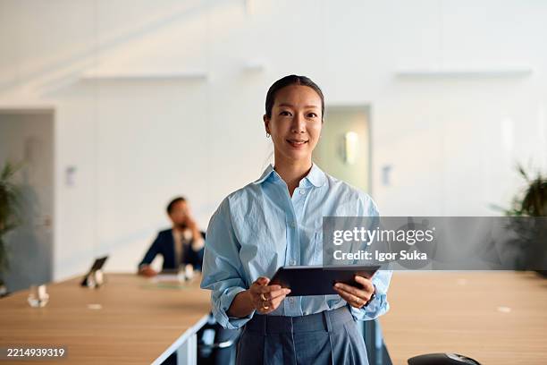 young asia businesswoman holding digital tablet in modern office - differential focus stock pictures, royalty-free photos & images