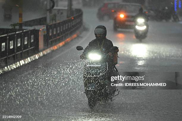 Man rides a scooter during heavy rainfall in Bengaluru on May 17, 2025.