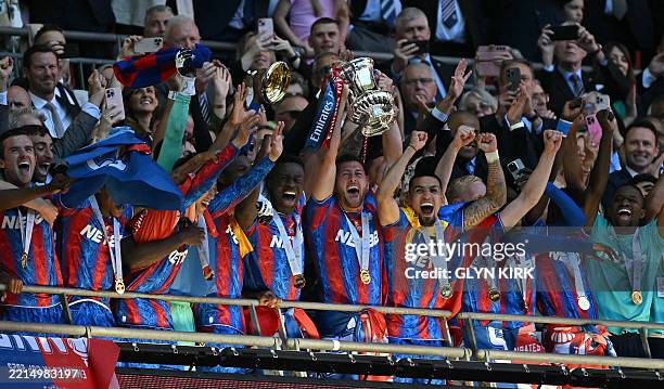 Crystal Palace's English defender Joel Ward lifts the trophy as Crystal Palace players celebrate after the English FA Cup final football match...