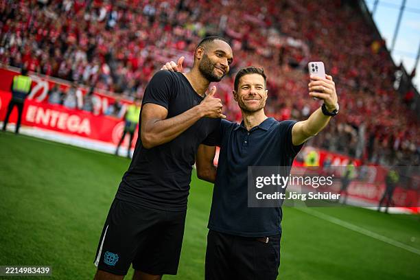 Jonathan Tah and head coach Xabi Alonso of Leverkusen pose for a selfie after the Bundesliga match between 1. FSV Mainz 05 and Bayer 04 Leverkusen at...