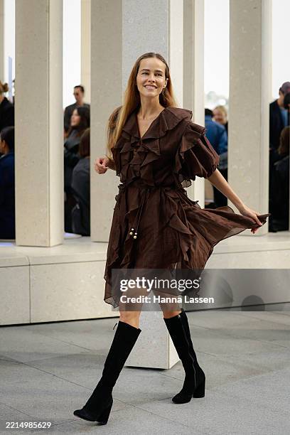 Isabel Lucas wearing brown ruffle dress and black boots during Australian Fashion Week 2025 on May 14, 2025 in Sydney, Australia.