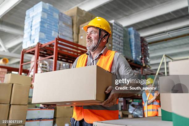 warehouse worker examining and packing boxes in a distribution center during a busy shift - image technique stock pictures, royalty-free photos & images