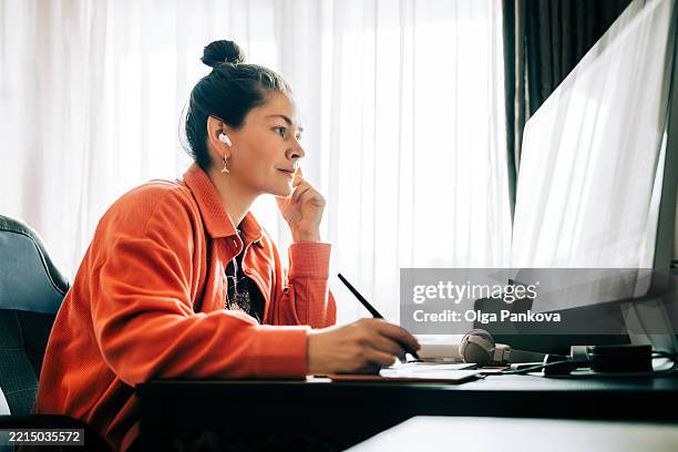 focused graphic designer working from home office using graphics tablet - grafiker stock-fotos und bilder