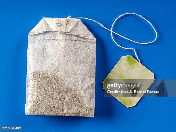 infusion of grasses of tea (tea bag ) on a blue background. - bustina foto e immagini stock