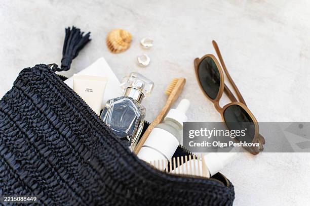 open blue cosmetic bag filled with travel essentials, including sunglasses, bottles, comb, toothbrush - bolsa de maquilhagem imagens e fotografias de stock