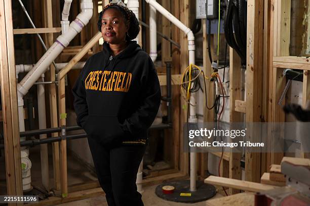Lori Burns stands near her sump pump, which was installed in 2022, in the basement of her home in Chicago's Chatham neighborhood on Wednesday, April...