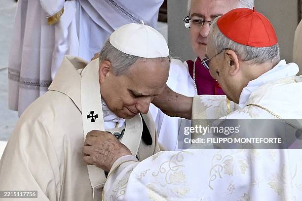 Pope Leo XIV receives the pallium by Italian Cardinal Mario Zenari during a mass for the beginning of his pontificate, in St Peter's square in The...