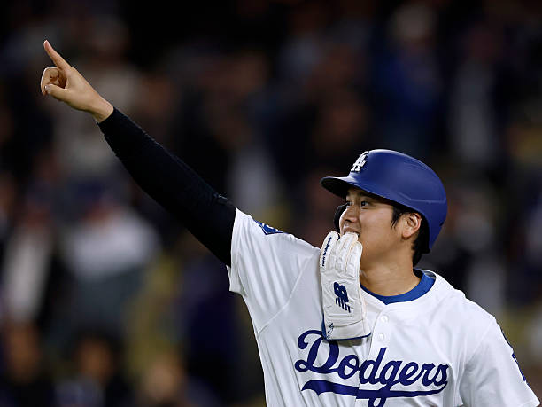 Shohei Ohtani of the Los Angeles Dodgers reacts after a two run double from Mookie Betts, to take a 6-3 lead over the Athletics, during the eighth...
