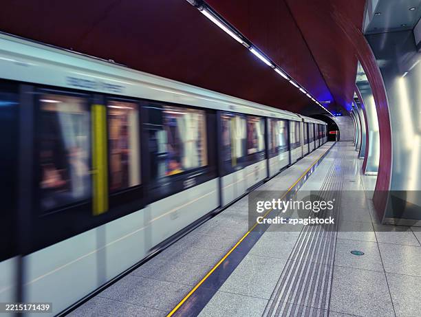 modern subway train in motion at futuristic metro station - m4 metro, budapest, hungary - underground rail stock pictures, royalty-free photos & images